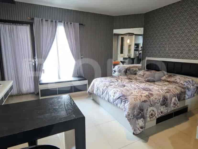 A modern bedroom with a large bed, patterned duvet, and window seat.