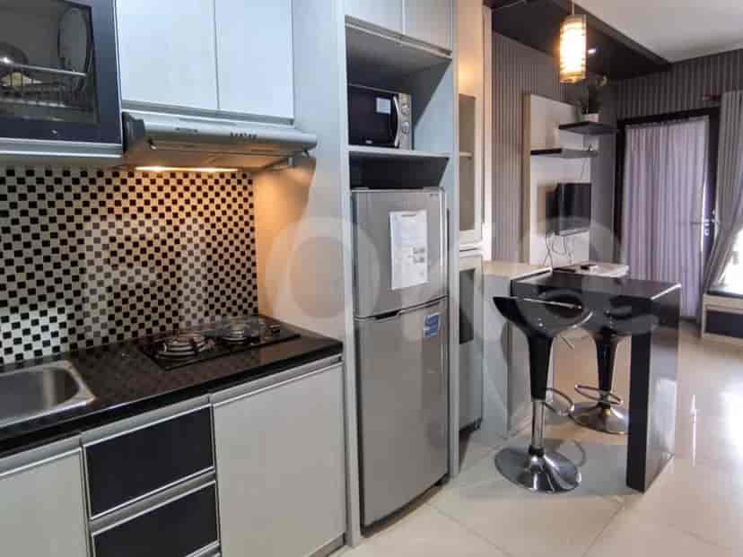A modern kitchenette with essential appliances and bar seating.