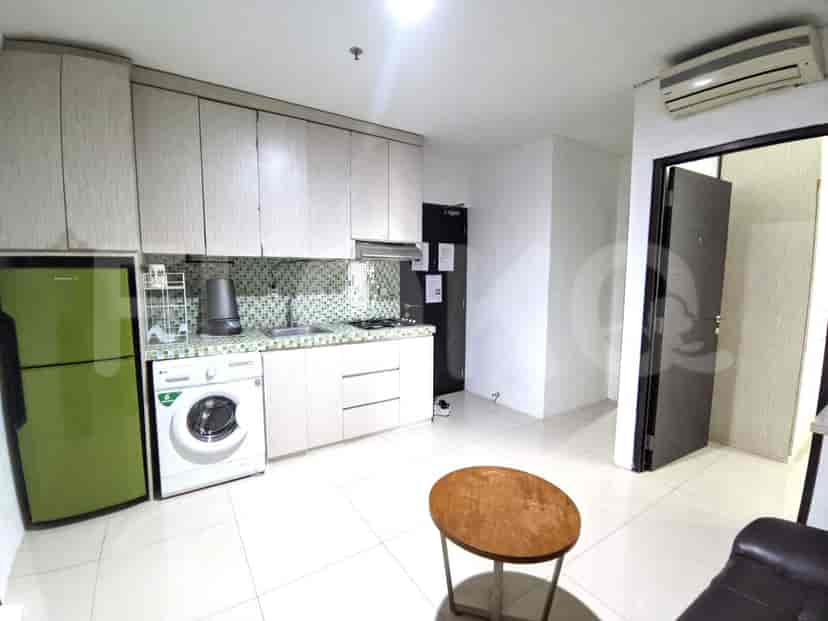 A kitchen area with a green refrigerator, a washing machine, and a gas stove.