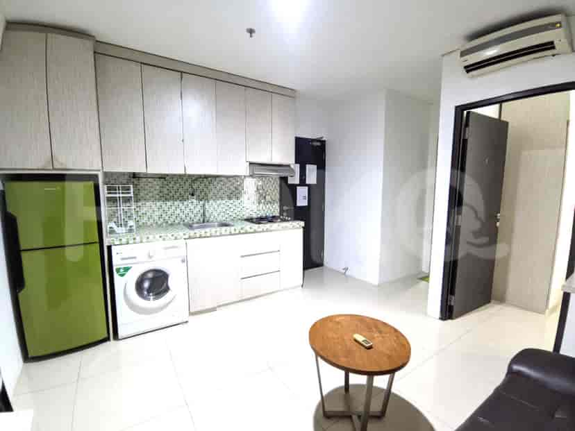 A kitchen area with a green refrigerator, a washing machine, and a gas stove.