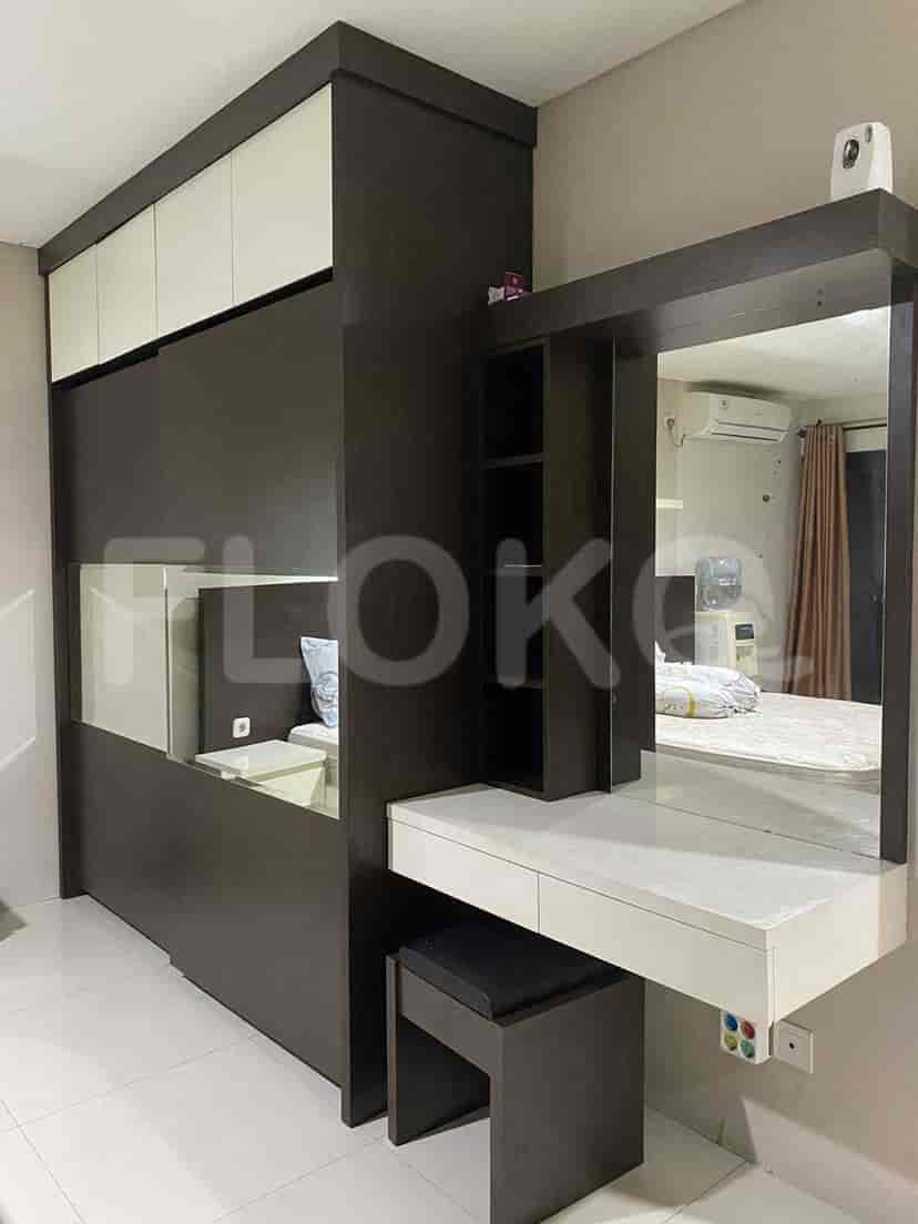 Bedroom featuring a vanity desk, closet, and a large mirror.