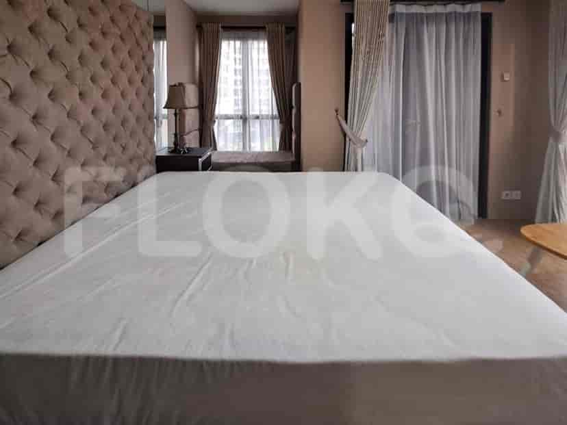 Contemporary bedroom with a tufted headboard, large bed, and window with curtains.