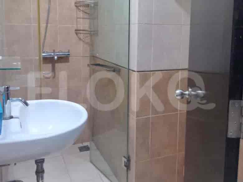A compact bathroom with a sink and a shower enclosure.