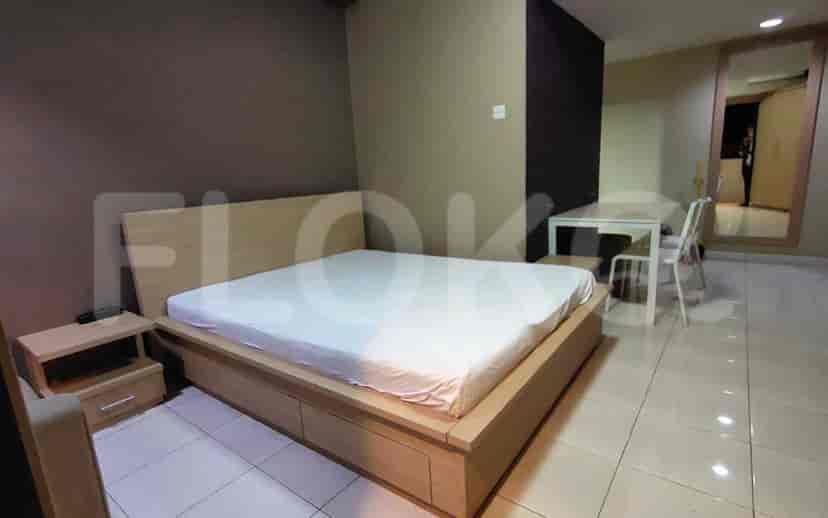 Another view of the bedroom showcasing the bed, side table, and dining area.