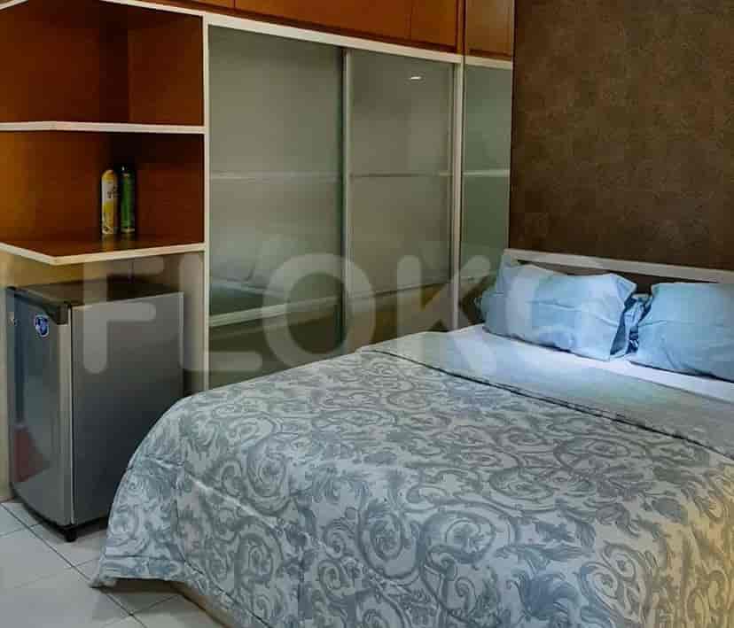 A living space with a sofa, TV, and mirror.