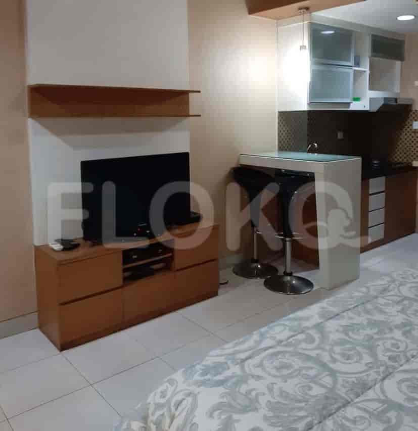 A compact kitchen featuring a bar, cabinets, and essential appliances.