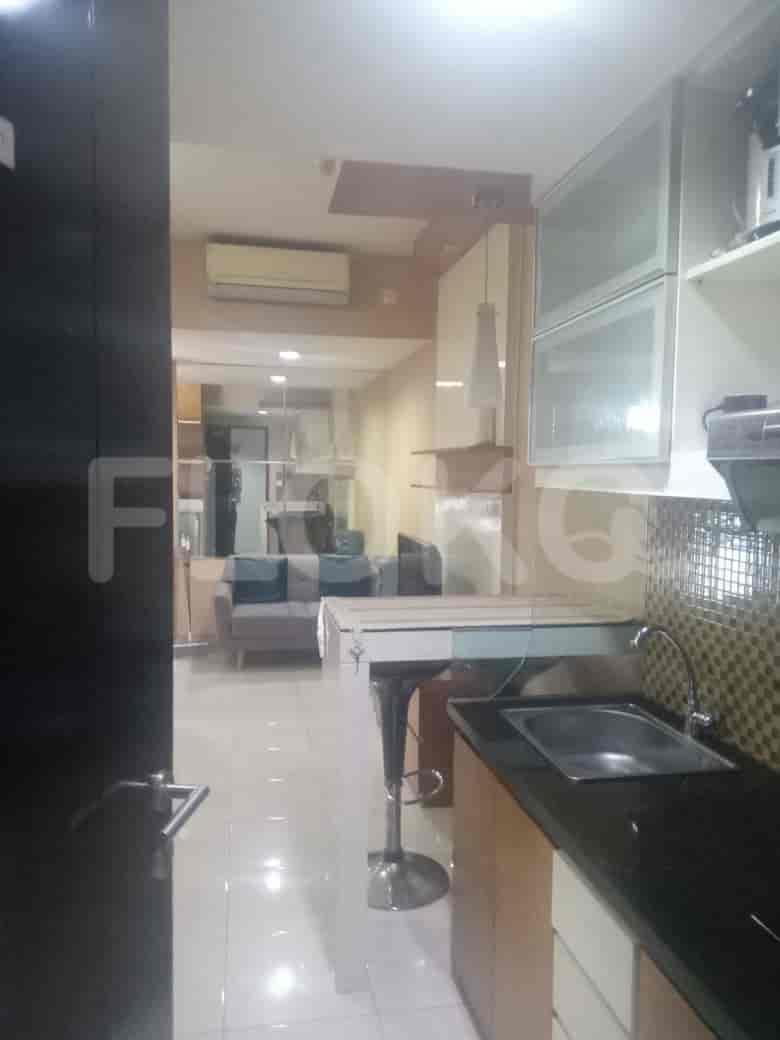A combined kitchen and living space with a bar, kitchen, and a glimpse of the living area.