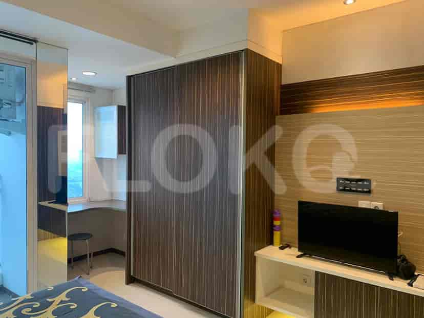 Kamar tidur dengan lemari pakaian, meja, dan jendela yang menghadap ke kota.