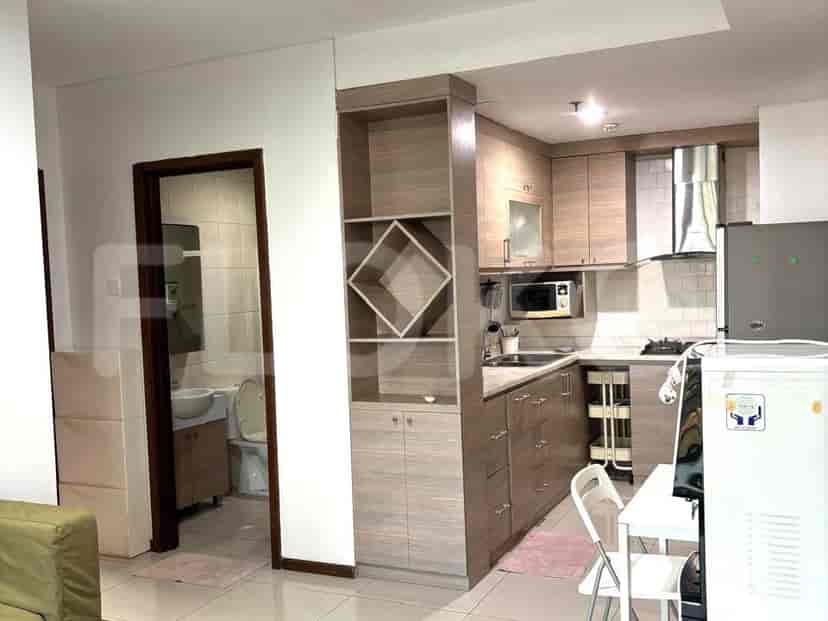 A well-organized kitchen with modern appliances, cabinets, and a view of the entrance.