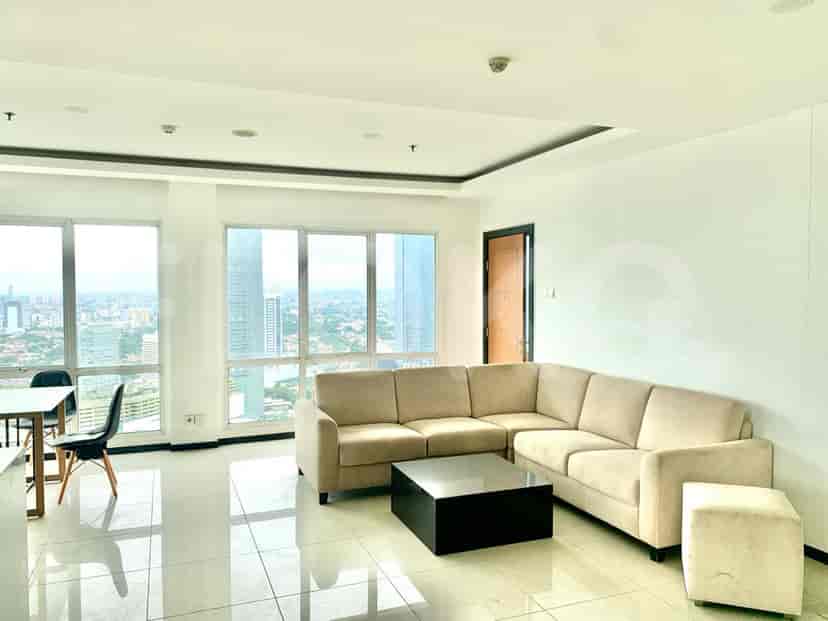 Modern living room with L-shaped sofa, coffee table, and city view.