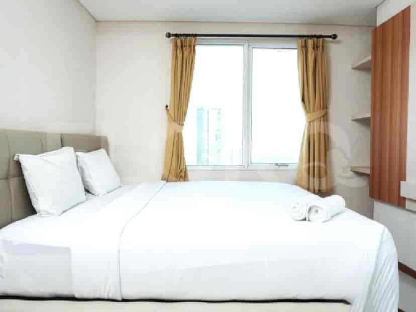 Kamar tidur cerah dengan tempat tidur putih dan jendela besar.