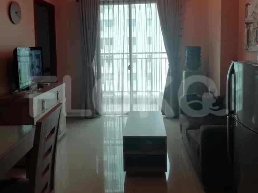 A living room with a sofa, TV, coffee table, and a large window.