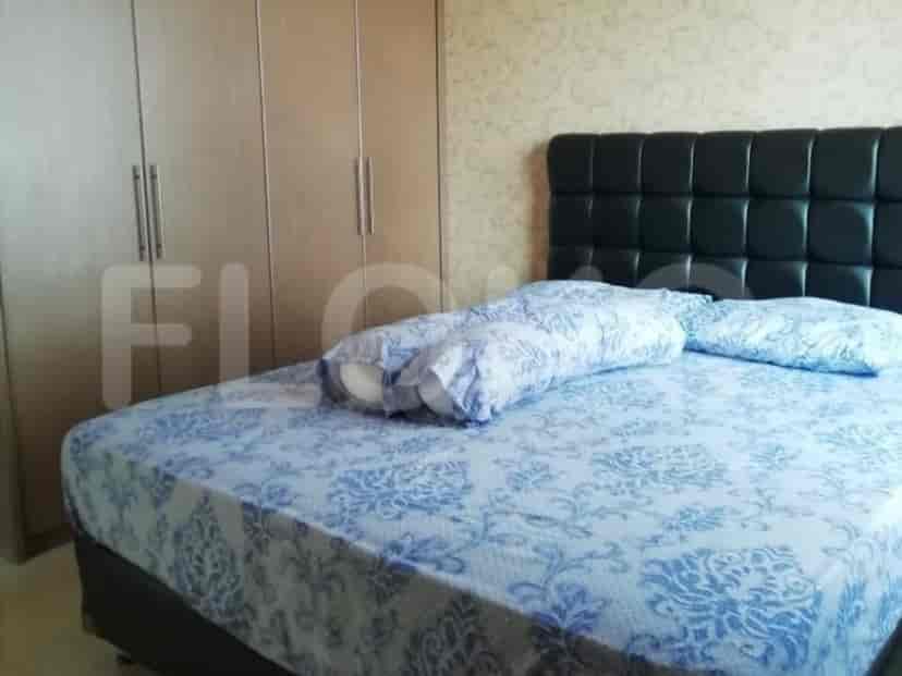 A bedroom with a bed, closet, and wallpaper.