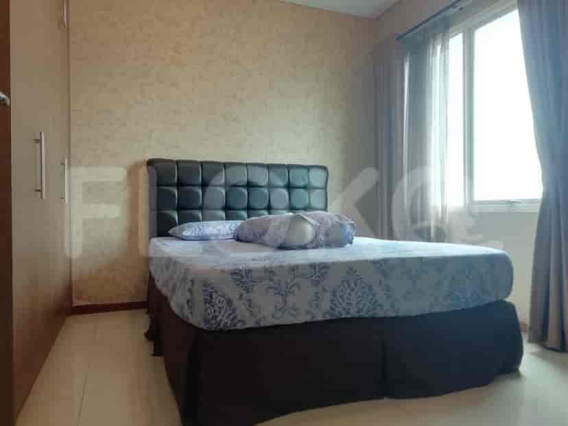 Another view of the bedroom with a bed and a large window.