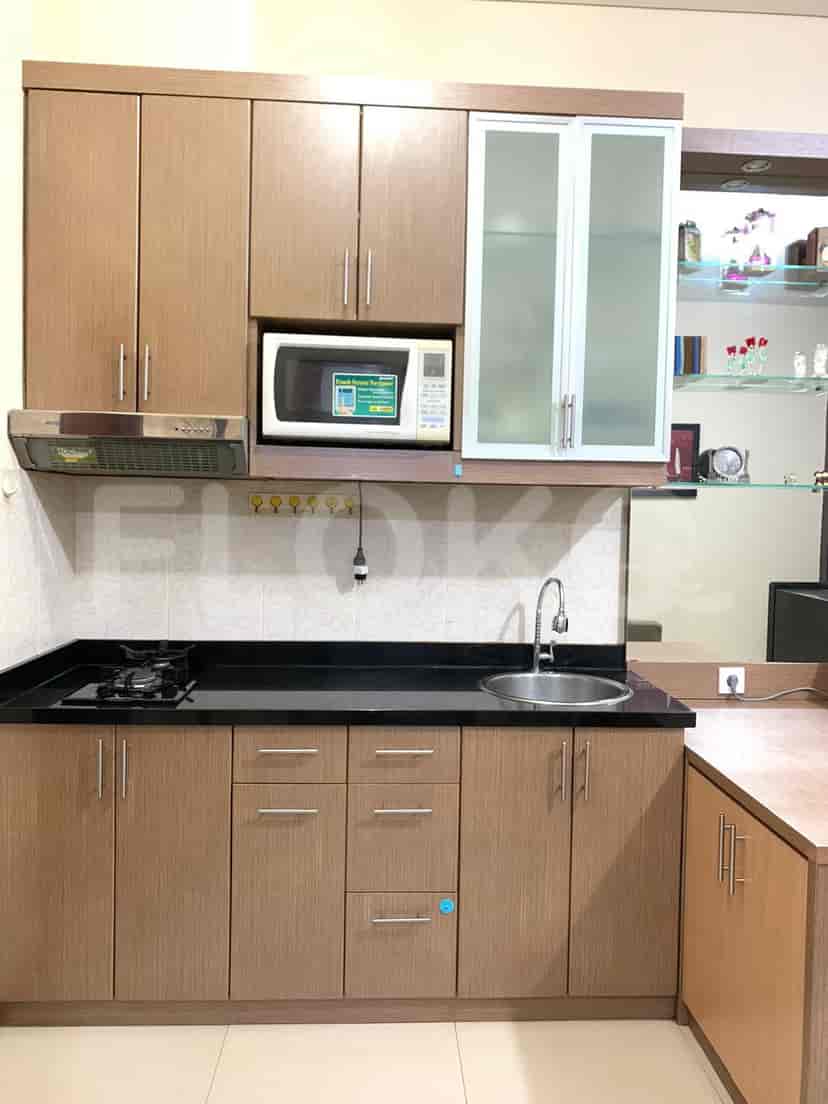 A modern kitchen with wooden cabinets, a black countertop, and stainless steel appliances.