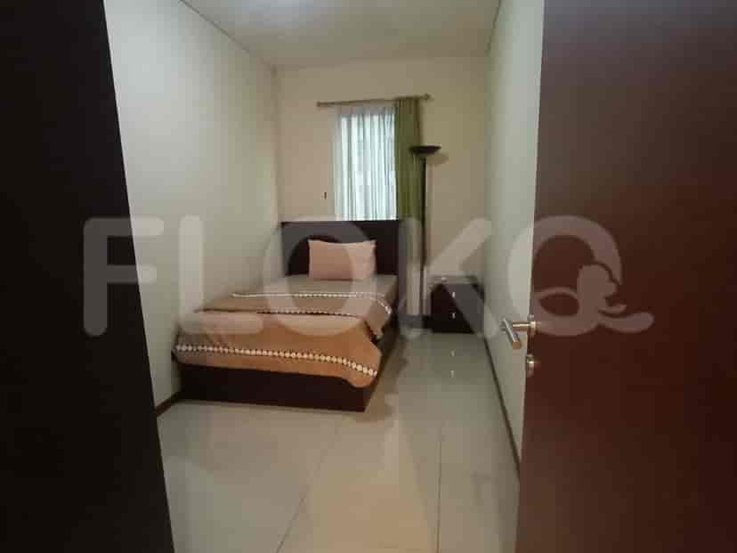 A small bedroom with a single bed and a neutral color scheme.