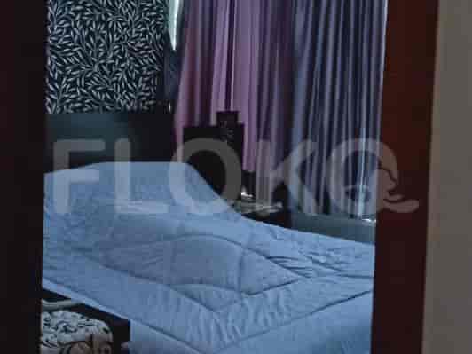 A view of the bedroom, showcasing the bed with a blue comforter and dark curtains.