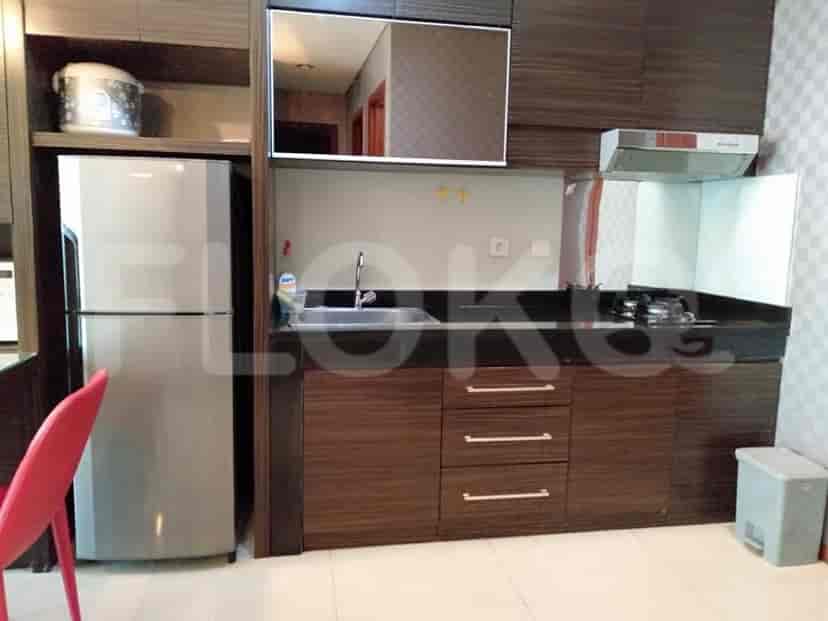 A modern kitchen with stainless steel appliances and dark wood cabinetry.