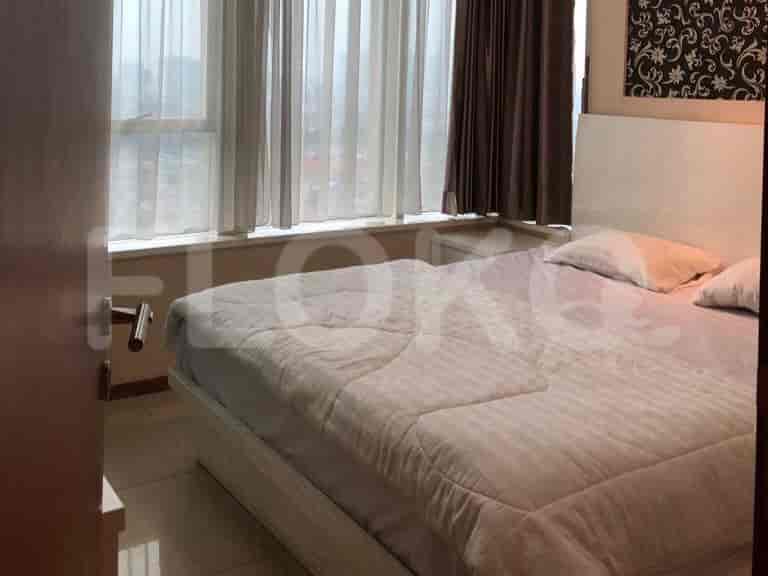 A bedroom with a large bed, sheer curtains, and a decorative wall.