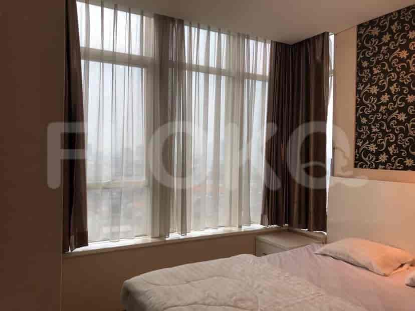 Bedroom with large window and curtains.