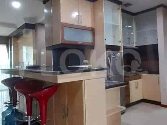 A well-equipped kitchen with a breakfast bar, cabinets, and a refrigerator.