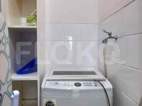 A clean bathroom with a washing machine and shelves.