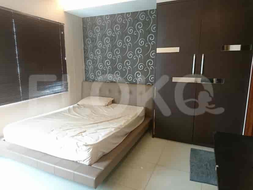 A bedroom featuring a double bed with a headboard, window with blinds, and a built-in wardrobe.