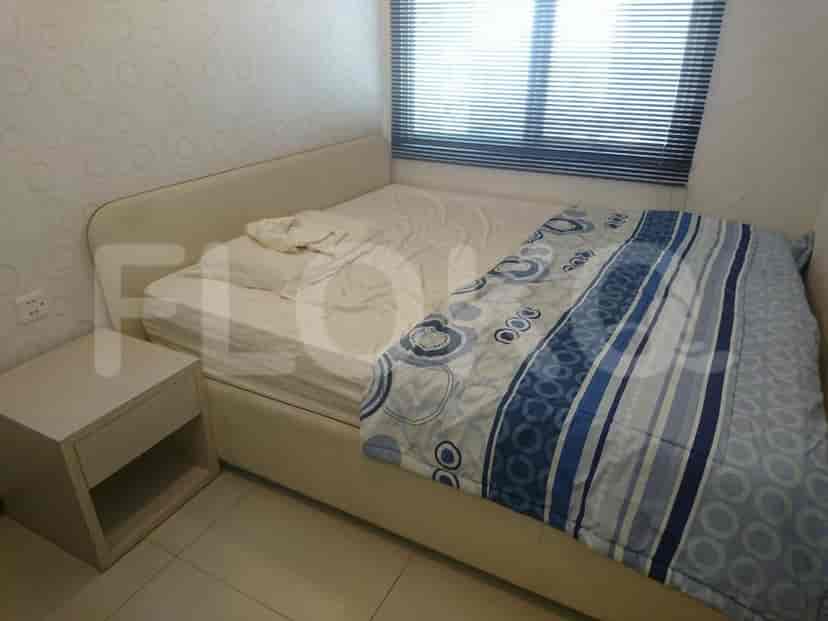 A bedroom with a bed covered with blanket, a bedside table.