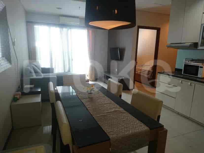 A dining and living area, including a dining table, sofa and TV.