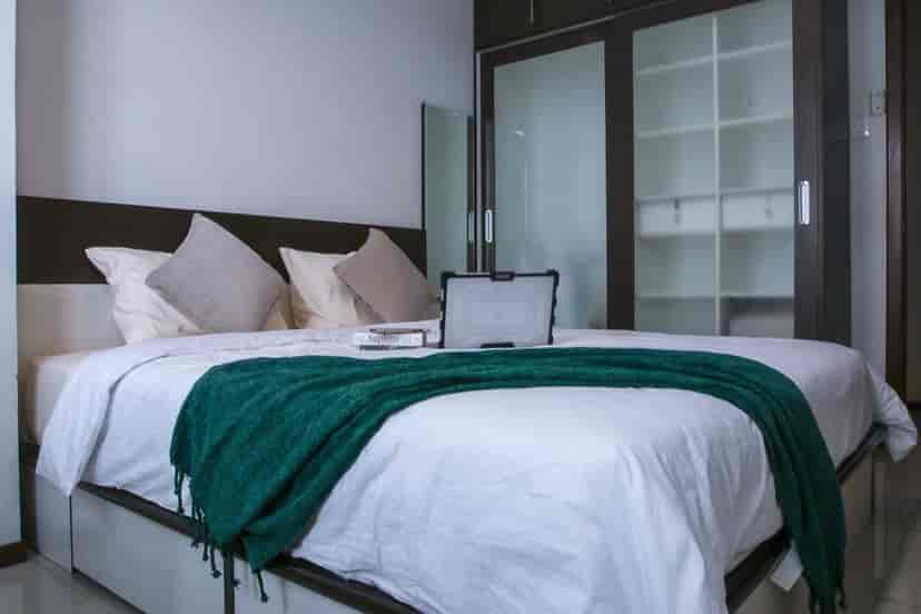 A modern bedroom featuring a queen-sized bed, wardrobe and a clean design.