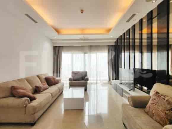Modern living room with sofa, armchair, white coffee table, and a large TV.