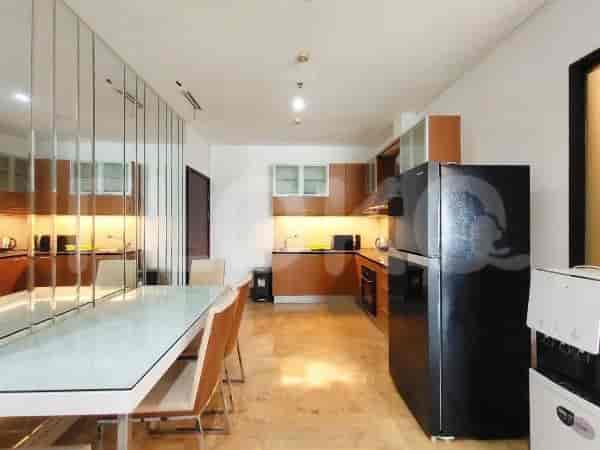 Modern kitchen with wooden cabinets, a dining table, and stainless steel appliances.