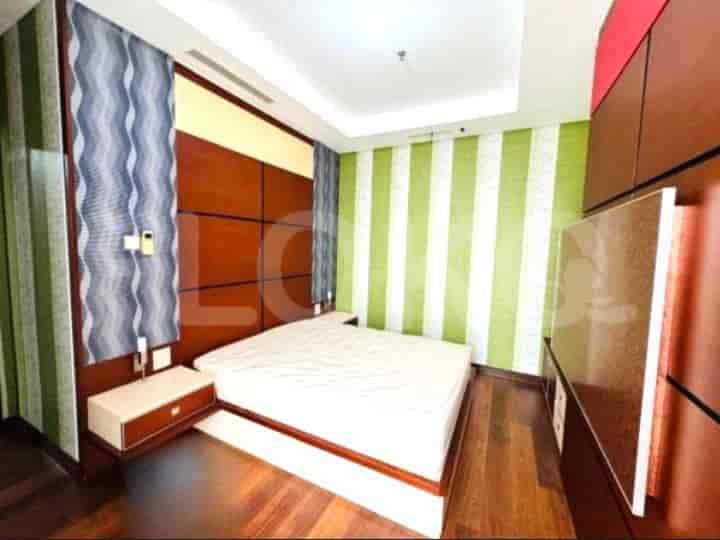 Bedroom with a white bed, wooden headboard, and colorful striped wall.