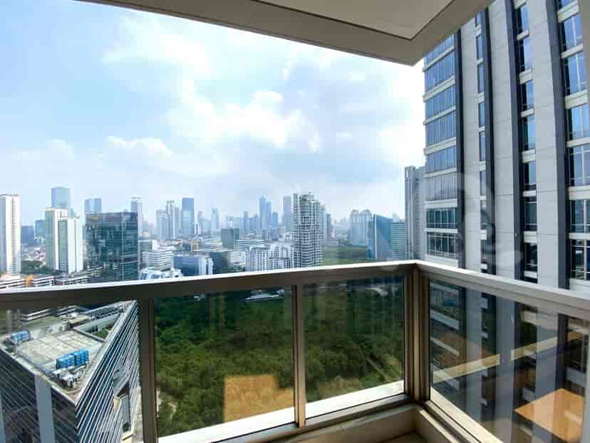 Balcony with a city view overlooking green space.