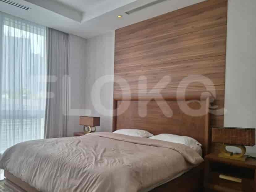 Bedroom with wood paneling, large windows, and bed.