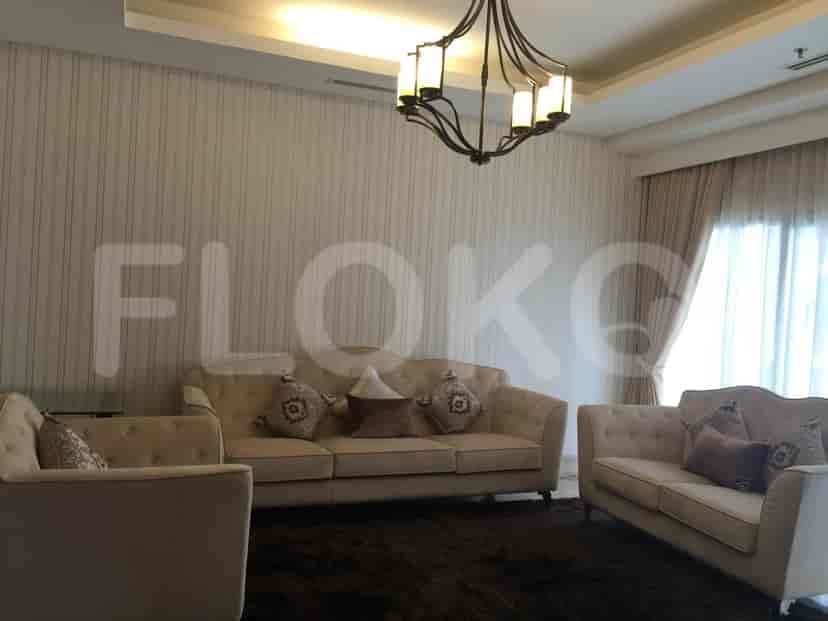 Ruang tamu dengan sofa krem, karpet, dan gorden.