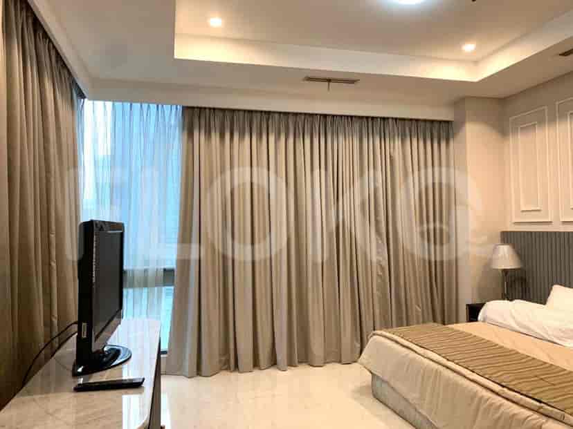 Bedroom with a bed, curtains, and a TV.