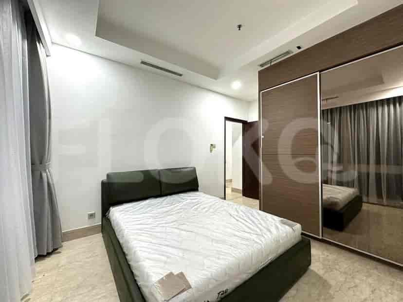 A bedroom with a bed, a wardrobe, and a window with curtains.