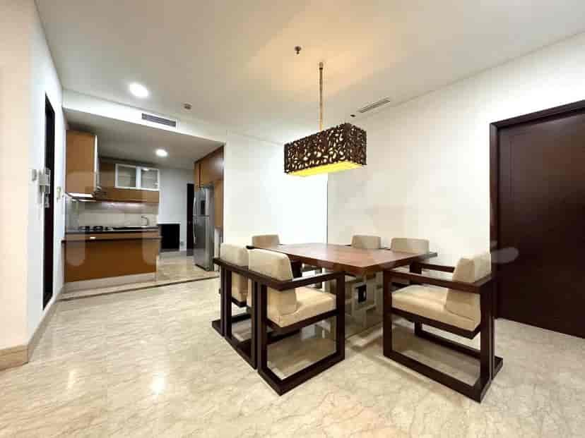 A dining area with a dining table and a view into the kitchen.