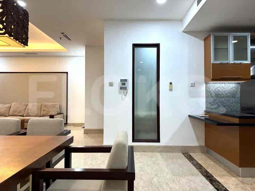 Meja makan dan dapur di latar belakang.