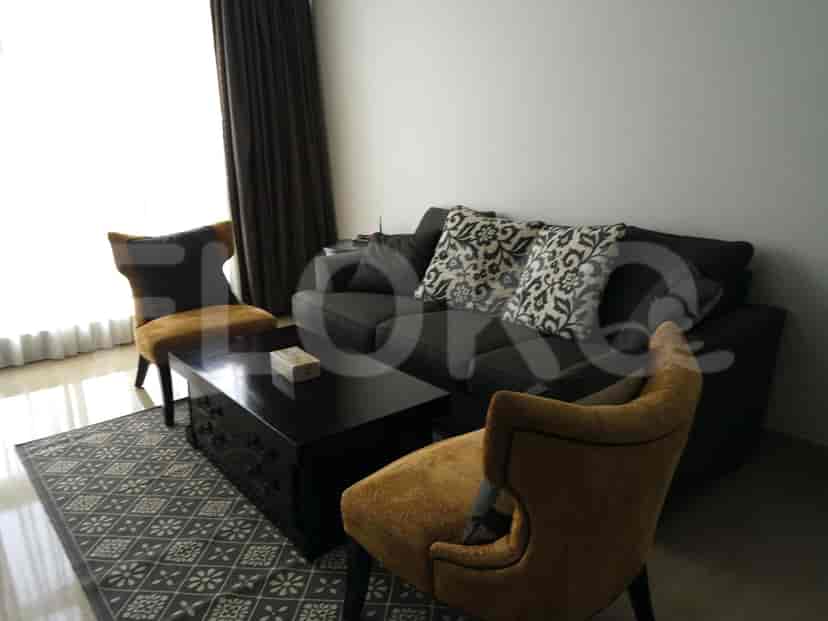 A living room with a dark grey sofa, two accent chairs, and a dark wood coffee table.