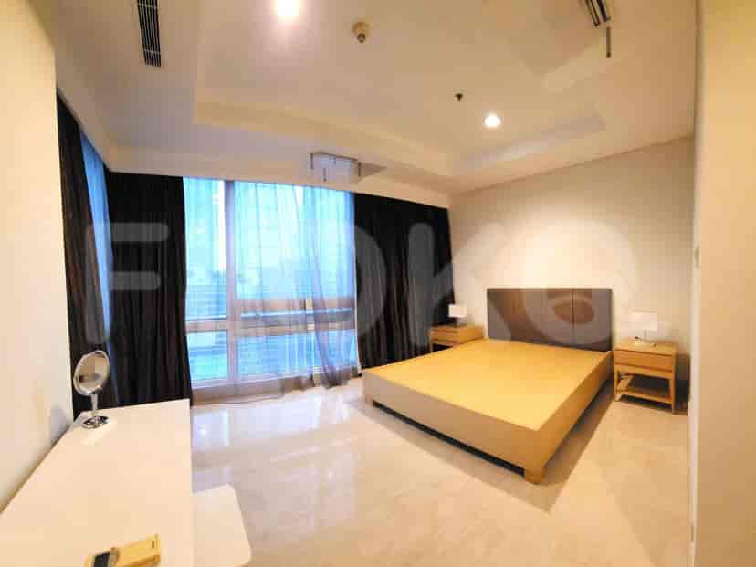 A bedroom with a king-size bed, side tables, and a vanity.