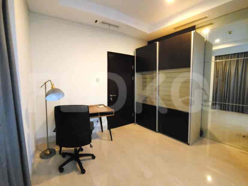 A study or bedroom with a desk, chair, and wardrobe.