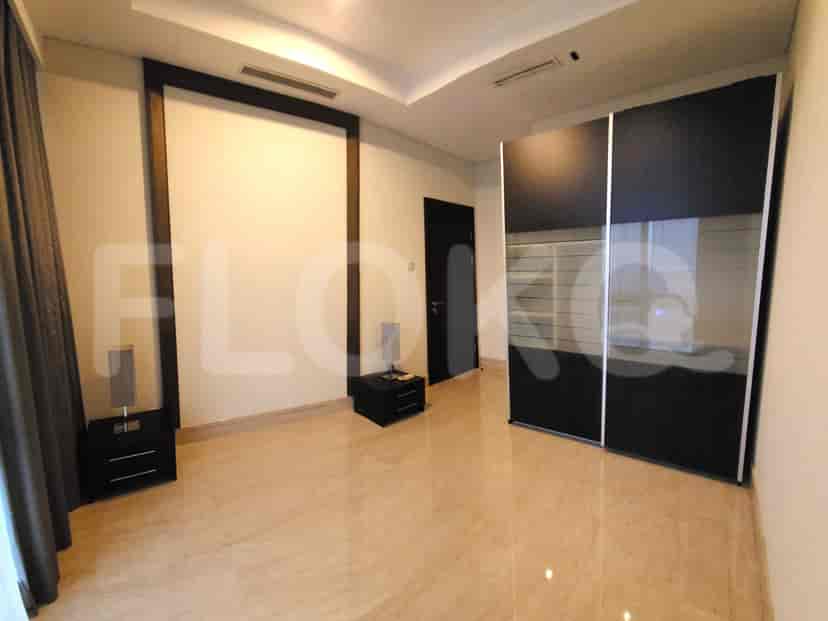 A bedroom with a king-size bed, side tables, and a wardrobe.