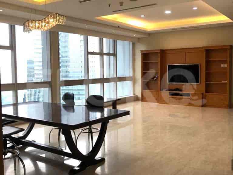 Living area with a dining table, TV, and wooden cabinets.