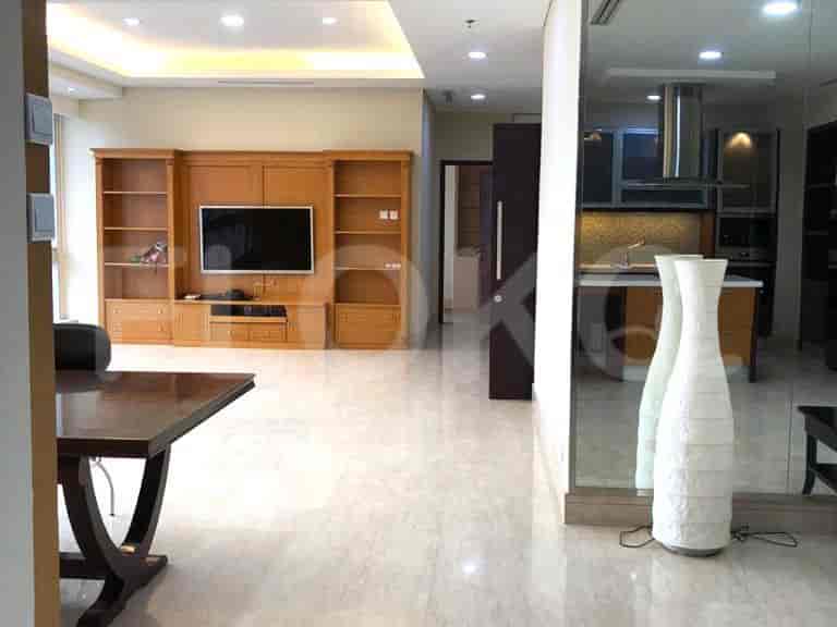 Living area with a dining table, and a view of the kitchen.