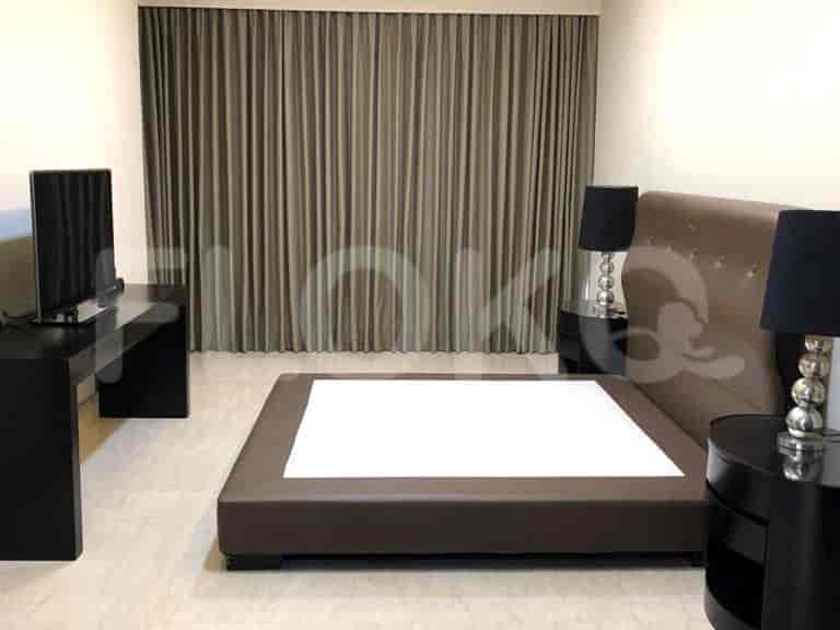 Bedroom with dark curtains, a bed, and a desk.