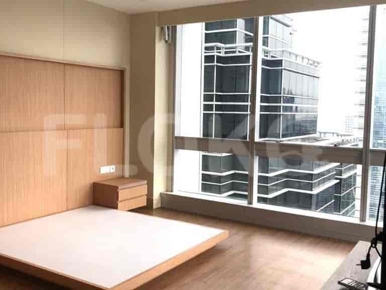 Bedroom with a wooden bed frame, and a window.