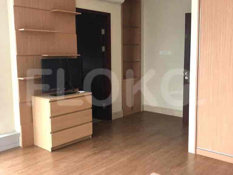 Bedroom with TV and wooden furniture.