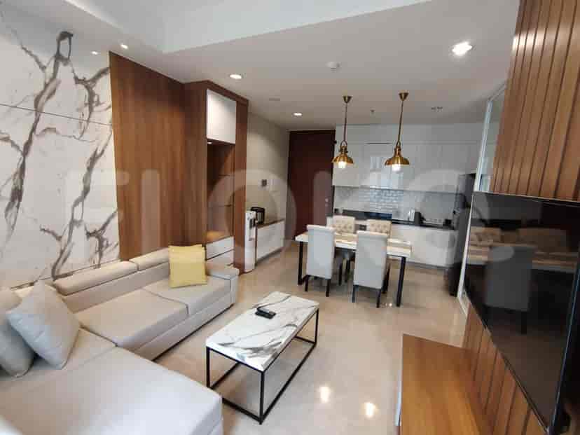 A modern living space with an L-shaped sofa, marble coffee table, and open kitchen.
